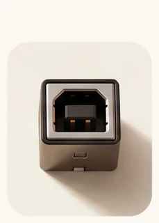 A USB type B socket, the tall squared chrome shell with two bevelled upper corners